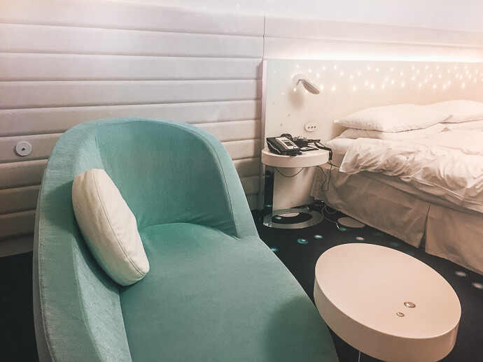 The Hilton Tokyo Bay's king Celebrio room with its aqua couch, star lit headboard, and retro futuristic styling