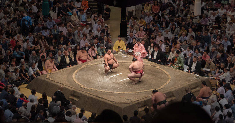 Two Sumo wrestlers Tokyo squat in front of each other