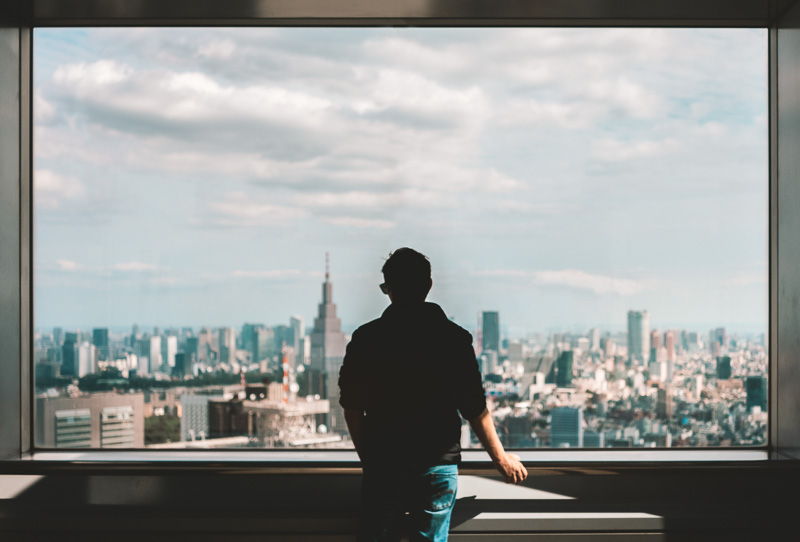 Man looks out over the view from the Tokyo Metropolitan Government Building, a great alternative thing to do in Tokyo