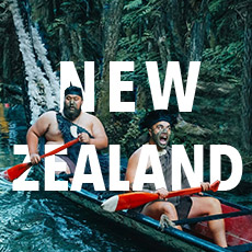 Two traditionally dressed Maori warriors padlding a wooden canoe downstream with the text 'New Zealand'  overlayed