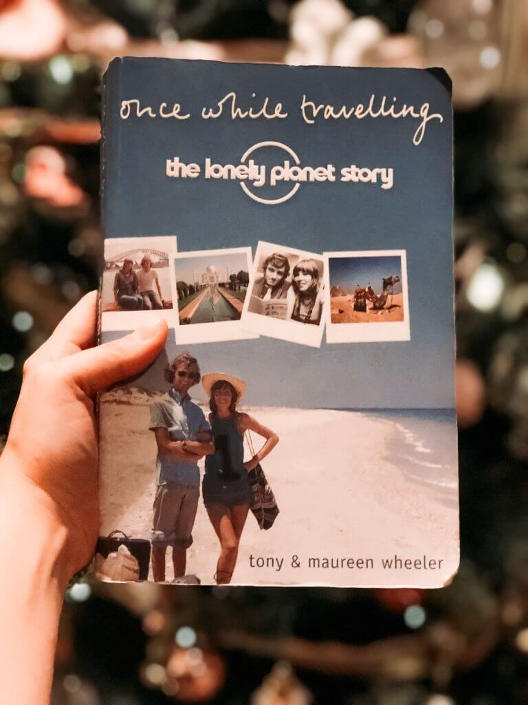 Once While Travelling book being held up in front of a Christmas tree