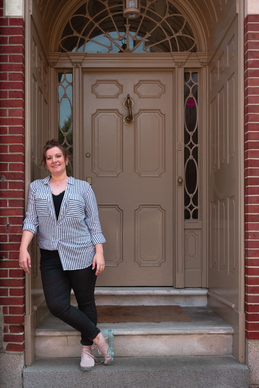 Amelia leaning against doorway in front of pretty door in Boston